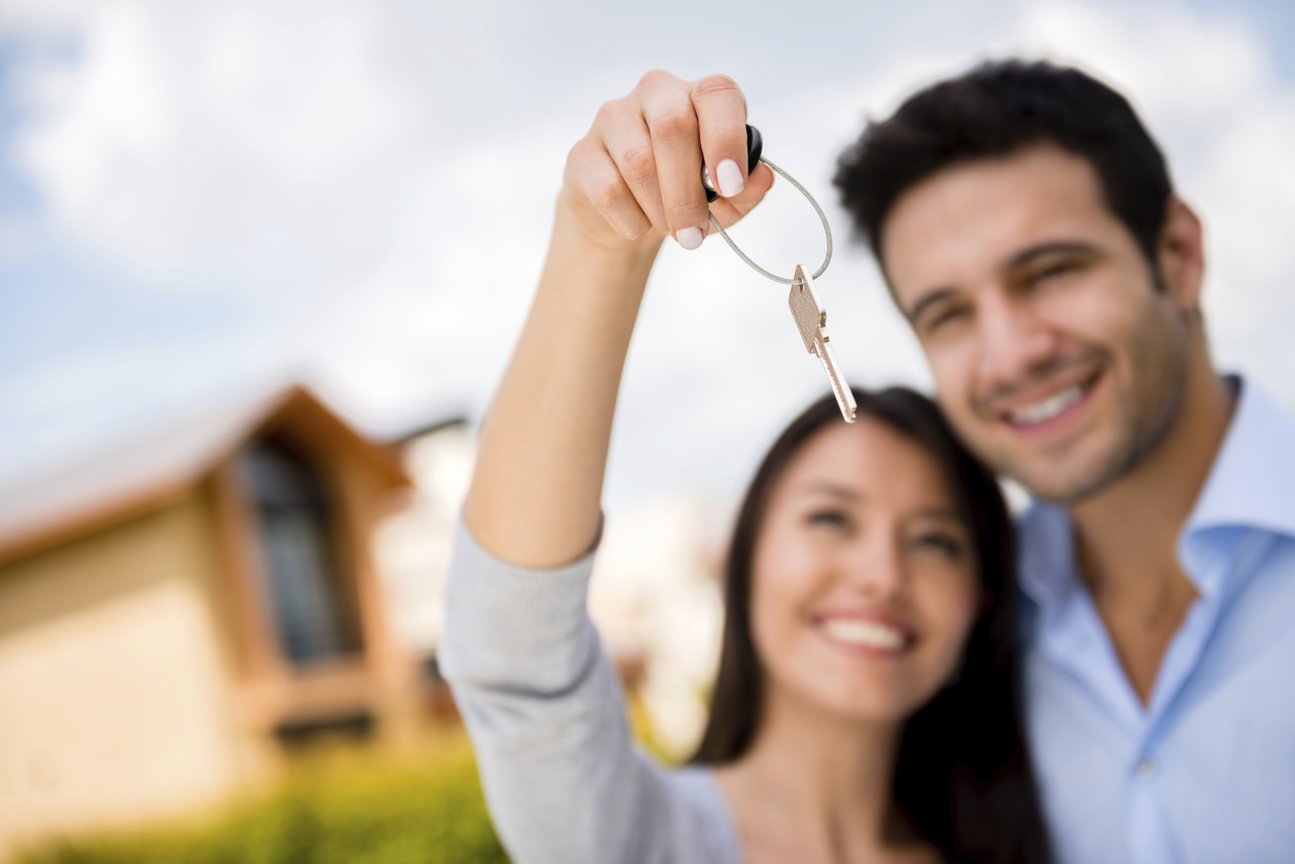 Couple holding house keys and looking very happy
